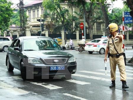 Cảnh sát giao thông ra hiệu lệnh dừng xe biển xanh trên phố Trần Phú, Hà Nội.